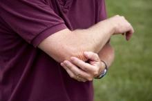 Iemand grijpt naar elleboog door tennisarm