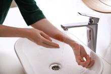 Iemand koelt een brandwond met lauw water
