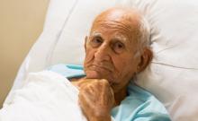 Een man in een bed heeft pijn bij kanker