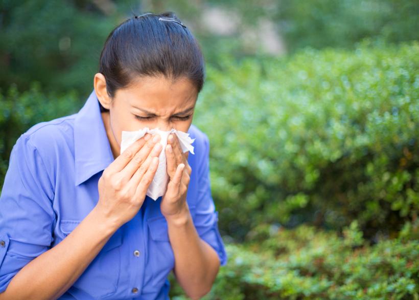 vrouw die in zakdoek niest