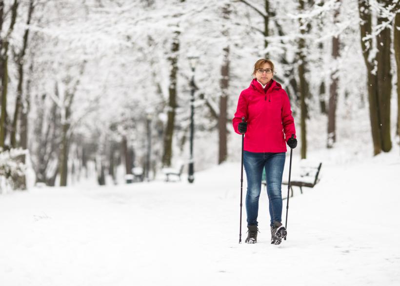 vrouw aan het nordic walken in de sneeuw