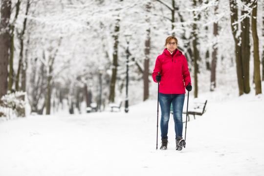 vrouw aan het nordic walken in de sneeuw