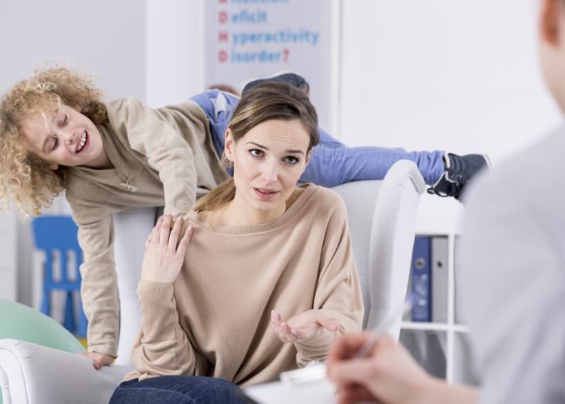 moeder met druk kind op de fauteuil