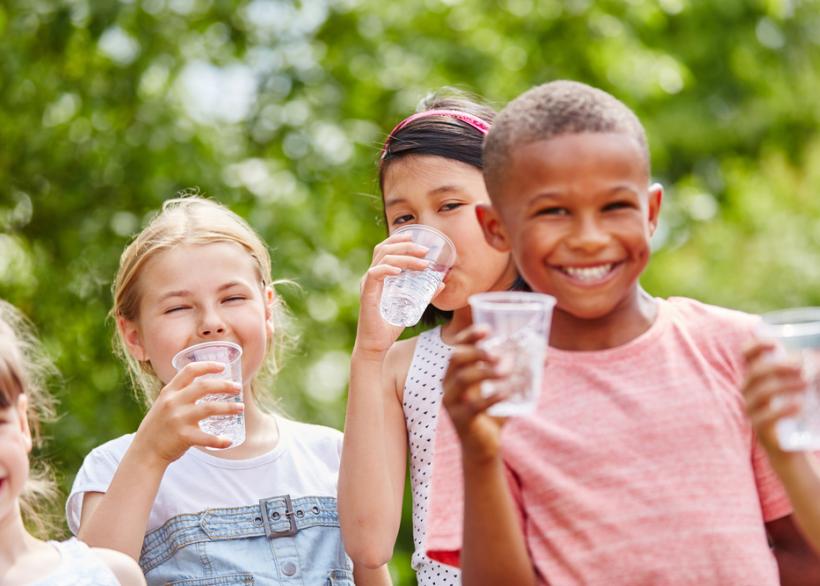 Kinderen die water drinken bij warm weer