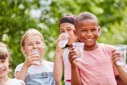 Kinderen die water drinken bij warm weer