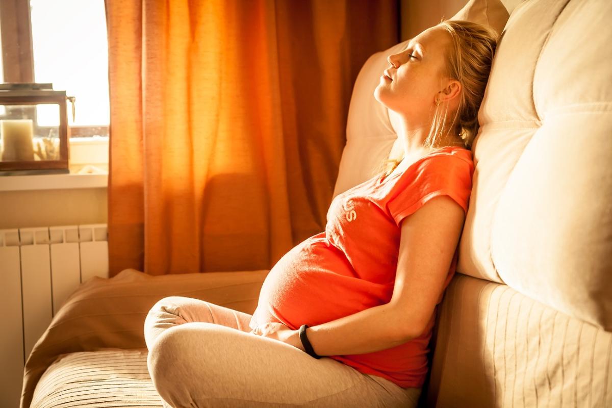 Een zwangere vrouw probeert te ontspannen tegen de pijn van een wee.