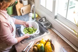Iemand wast groenten om zweepwormen te voorkomen