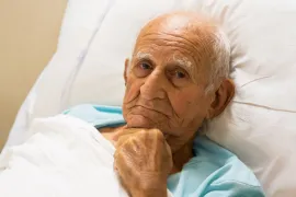 Een man in een bed heeft pijn bij kanker