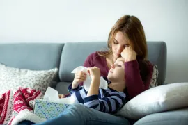 vrouw en kind verkouden op bank