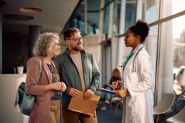 Een vrouw en een man praten met een arts in het ziekenhuis