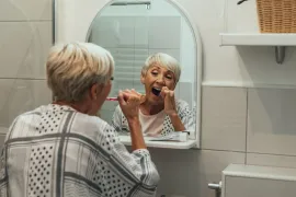 vrouw met mondproblemen in de laatste fase van haar leven poetst tanden