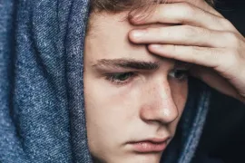 Sombere jongen met capuchon op